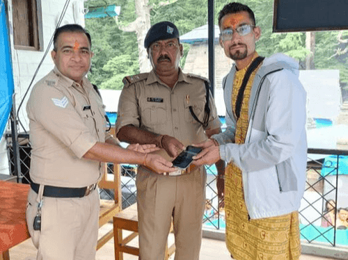The police personnel handed over the lost mobile phone to its owner